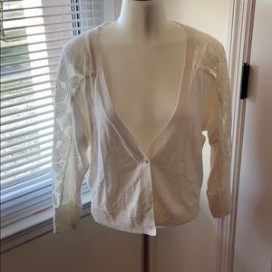 Woman’s button up cardigan with lace sleeves.